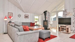 A modern living room with a sofa, ottoman, and a TV stand with a flat-screen TV. - Amazing home in Fanø with WiFi (Fanø)