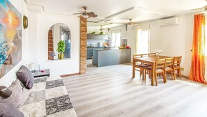 A spacious living area with a wooden dining table and chairs, a sofa, and a ceiling fan. - Amazing home in Orihuela Costa (Orihuela Costa)