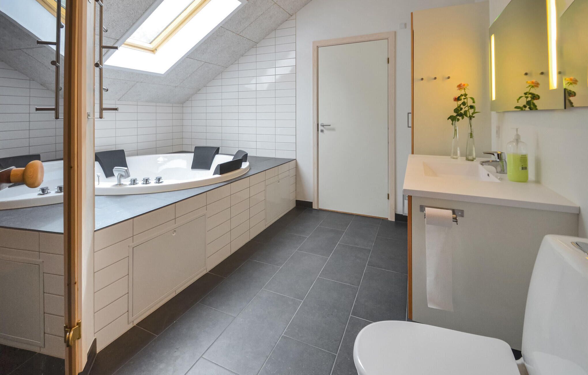 A modern bathroom with a freestanding bathtub, a separate sink, and a toilet.