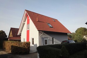 A two-story house with a red-tiled roof, a white exterior, and a small window on the second floor. - Holiday house Seeblick-Fleesensee (Göhren-Lebbin)