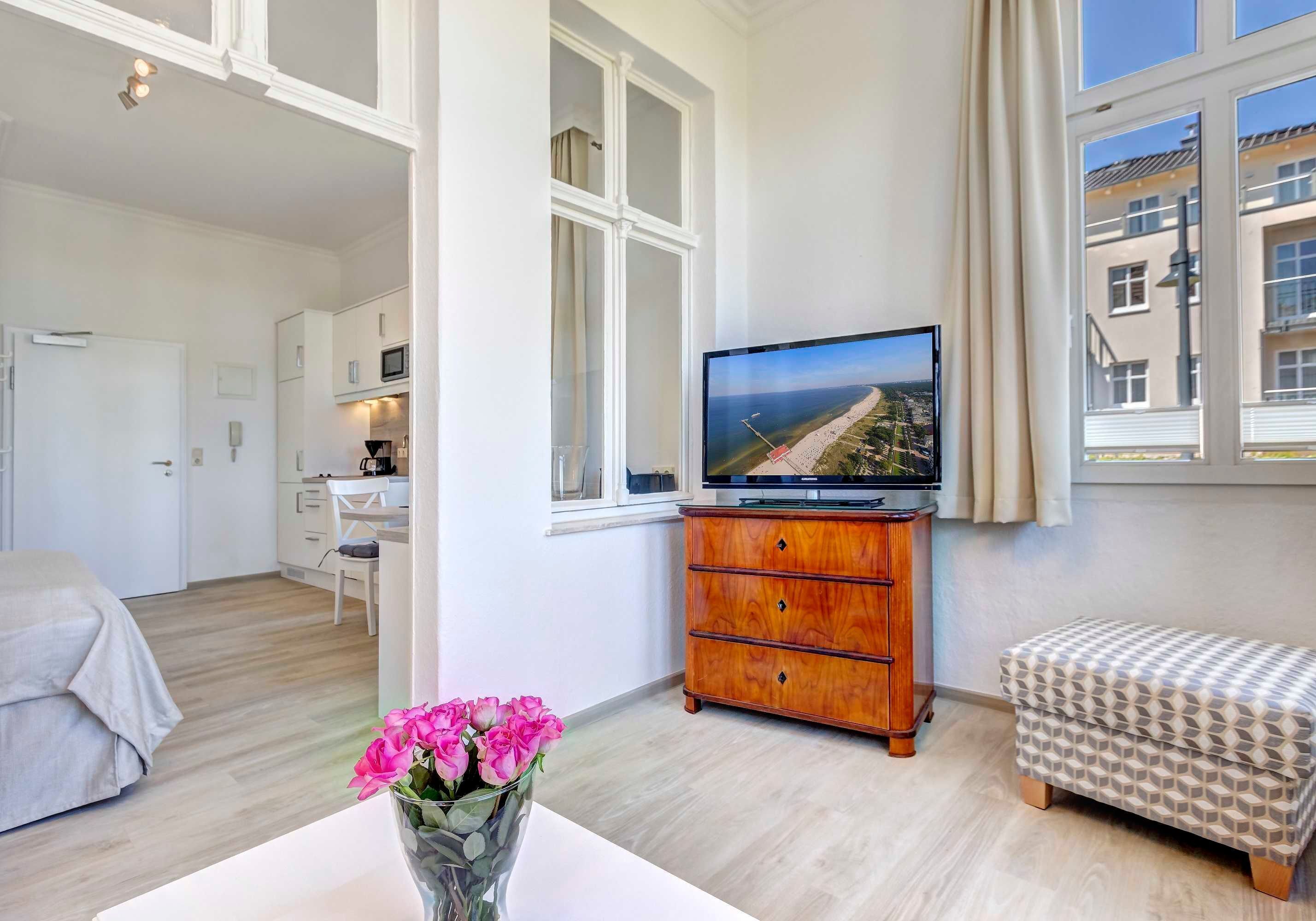 Ein modernes Hotelzimmer mit Bett, Schreibtisch, Fernseher und Meerblick.