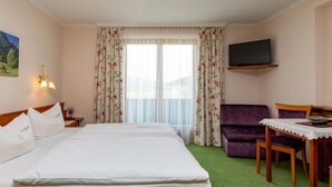 A hotel room with a bed, a sofa, a table, and a TV. - FW I - Pension ANNA, Apartments & Comfort Rooms *** (Keuschen)