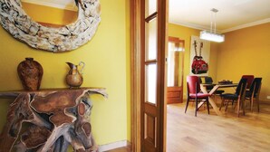 Un coin repas avec une table et des chaises en bois, un vase et un élément décoratif original au mur.