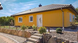 Um edifício amarelo com telhado telhado e janelas.