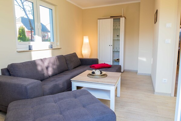 A living room with a grey sofa, a white coffee table, and a cabinet.