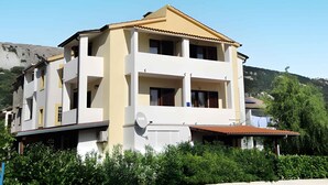 A two-story building with a flat roof and a satellite dish.