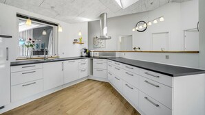 A modern kitchen with white cabinetry, a wooden countertop, and a skylight. - 3 bedroom gorgeous home in Skjern (Skjern)