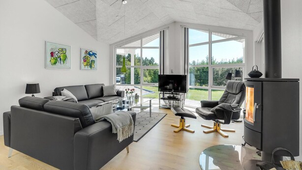 A modern living room with a sofa, TV, and fireplace. - 3 bedroom gorgeous home in Skjern (Skjern)