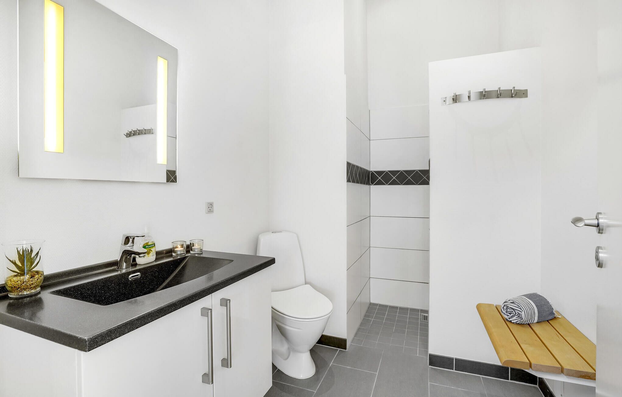 A modern bathroom with a sink, toilet, and shower area.