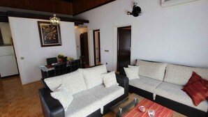 Ein Wohnzimmer mit einer Couch, einem Couchtisch und einem Essbereich mit Tisch und Stühlen.