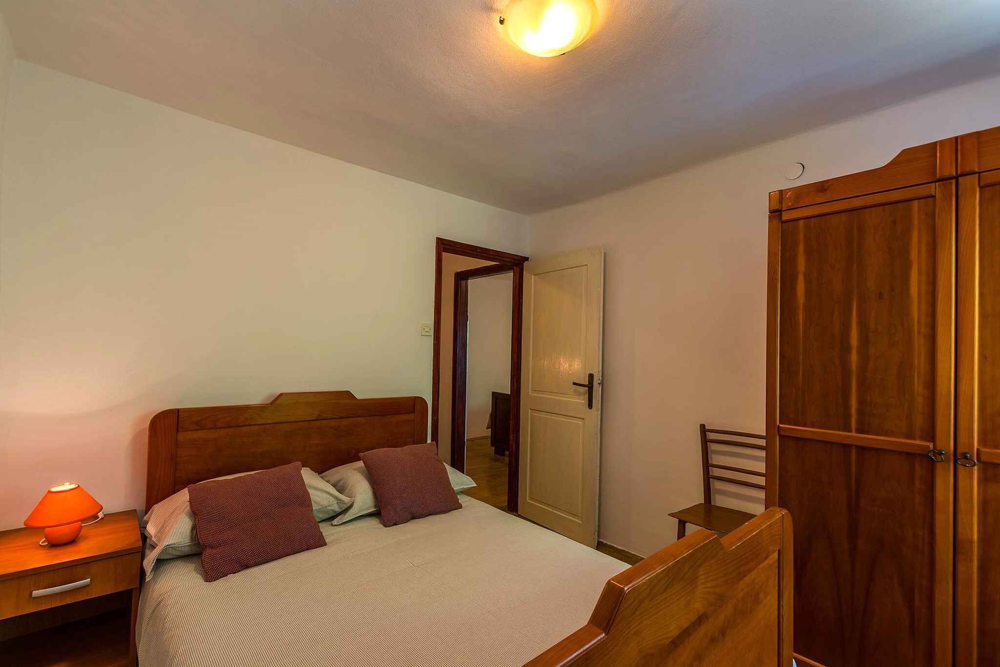 Ein Schlafzimmer mit einem Bett, einem Nachttisch, einem Kleiderschrank und einer Tür.