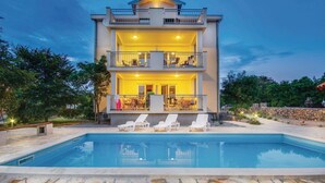 Un edificio de dos pisos con una piscina al frente.