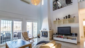 A spacious living room with a fireplace, a television, and a balcony with outdoor furniture. - Amazing home in Ciudad Quesada-Rojales (Ciudad Quesada-Rojales)