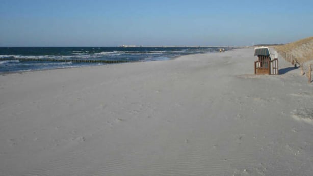 A beach with a small wooden structure, possibly a lifeguard station, and a sandy shore. - Haus Bernstein 3 - Apartment Bernstein 3 (Graal-Müritz)