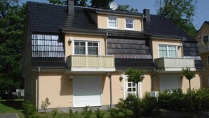A two-story residential building with a flat roof, a satellite dish, and a garage. - Haus Bernstein 3 - Apartment Bernstein 3 (Graal-Müritz)