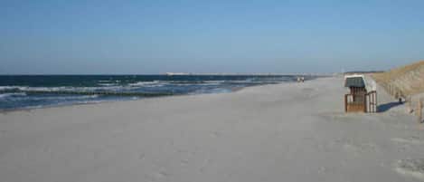 A beach with a small wooden structure, possibly a lifeguard station, and a sandy shore.