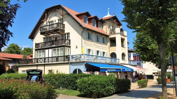 Ein zweistöckiges Gebäude mit Balkon, überdachter Außenbereich und einem Schild für ein Restaurant.