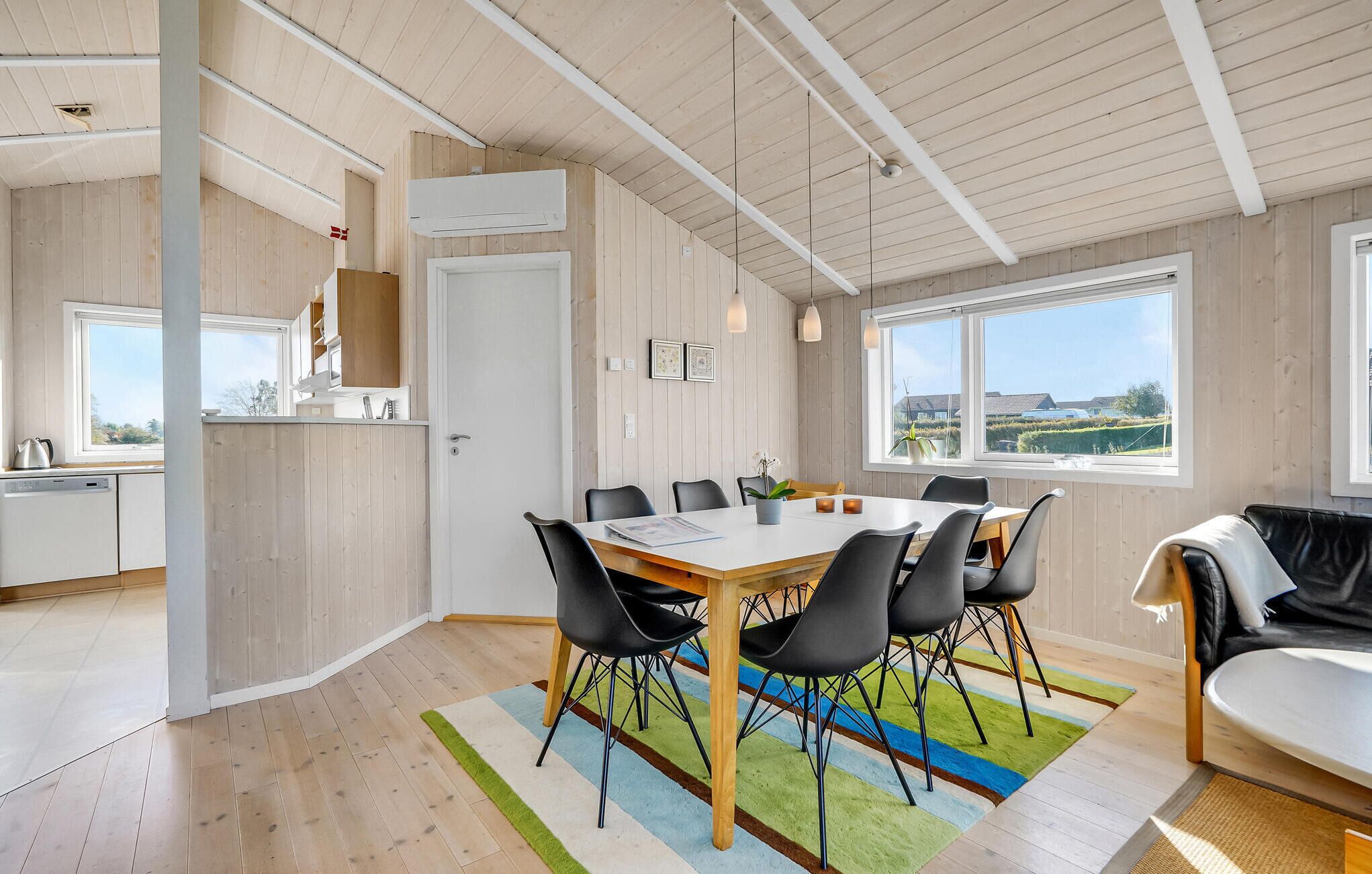 Een moderne keuken met witte kasten, een vaatwasser en een raam met uitzicht op een tuin.