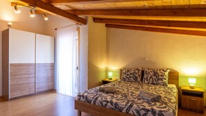 Une chambre à coucher avec un lit en bois, deux lampes de chevet et une grande fenêtre avec des rideaux.