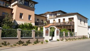 A multi-story residential building with balconies, a gated entrance, and a clear sky. - Residence Seestern Whg S-13. - See-13 (Kühlungsborn)