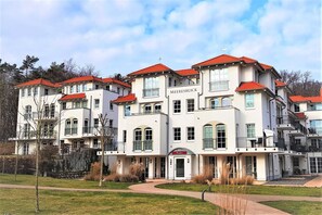 Un immeuble à plusieurs étages, doté d’un toit rouge, de balcons et d’une enseigne sur laquelle on peut lire « MEERESBLICK ».