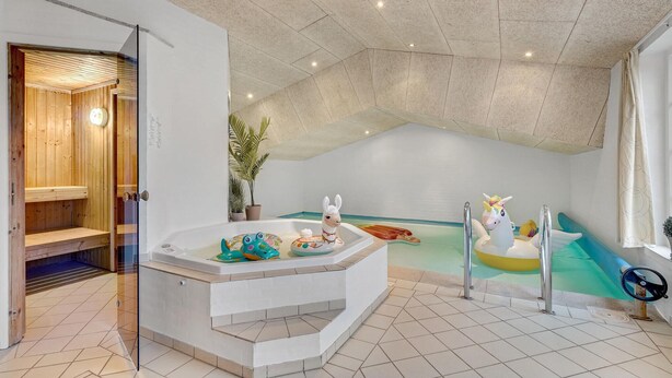 A modern bathroom with a freestanding bathtub, a children's play area, and a wooden sauna. - Amazing home in Oksbøl with sauna (Oksbøl)