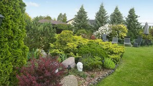 Ein gepflegter Garten mit verschiedenen Sträuchern und einem Kiesweg.
