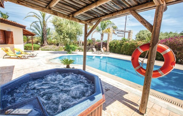 A hot tub, a swimming pool, and lounge chairs in a sunny outdoor setting. - 3 bedroom nice home in Laatchi (Laatchi)