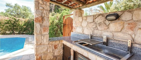 Enjoy al fresco dining and entertaining in this inviting outdoor space with a grill and sink.