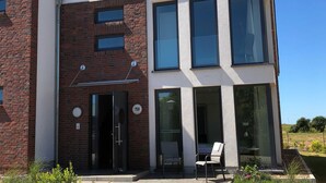 A modern building with a brick facade, large windows, and a door with a sign. - Apartment 10 - gate to the sea (Helgoland)