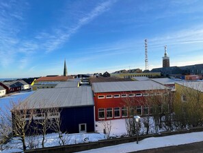 A residential area with multiple buildings, a church spire, and a tall communication tower. - Apartment 10 - gate to the sea (Helgoland)