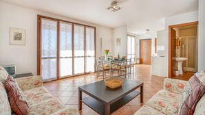 A spacious living area with a dining table, chairs, a sofa, and a coffee table. - Beautiful apartment in Agra (VR) with outdoor swimming pool (Agra (VR))