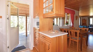 Eine Holz-Küche mit integriertem Mikrowellenherd, Holdschränken und einem Essbereich mit Holzstühlen und einem Tisch.