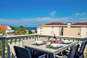 A terrace with a table set for two, overlooking a coastal view. - Holiday apartment with 2 terraces (Vantačići)