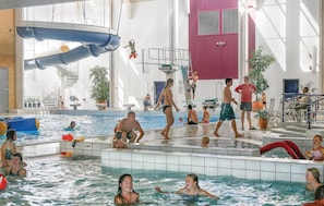 An indoor swimming pool with multiple lanes, a diving board, and a water slide. - Skærbæk Fritidscenter (Skærbæk)