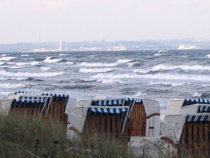Des chaises de plage à rayures, disposées face à la mer.