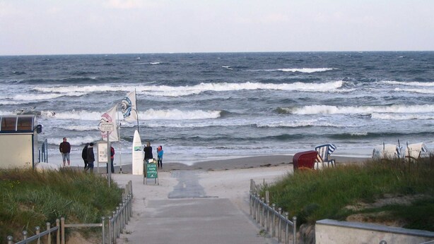 A coastal walkway leading to the beach with a sign indicating 'Streer kust' and a lifeguard station. - Bergen: stylish apartment with parking space and beach chair - FeWo Bergen (Binz)