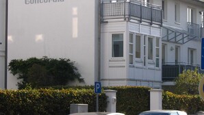 A building with a sign reading "Concordia" and a parking sign. - Bergen: stylish apartment with parking space and beach chair - FeWo Bergen (Binz)