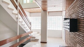 A staircase with wooden handrails and a brick wall with a mounted object.
