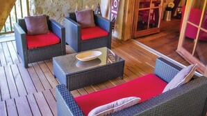 A covered outdoor seating area with wicker furniture and red cushions. - Awesome home in Masseube with sauna (Masseube)