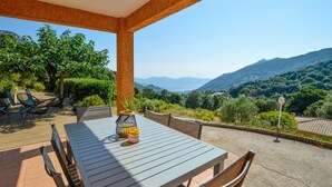 An outdoor patio with a table and chairs, a citronella candle, and a view of mountains and greenery. - 3 bedroom awesome home in Casalabriva (Casalabriva)