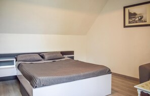 Une chambre à coucher avec un lit, une table de chevet, une chaise et un tableau au mur.