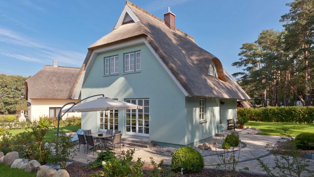 A house with a steeply pitched roof, a thatched roof section, and a light blue exterior. - Aquamaritim beach house (Loddin)