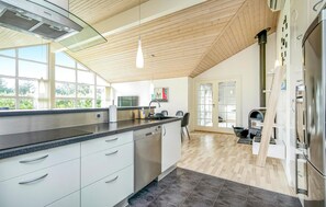 A modern kitchen with a large island, stainless steel appliances, and a view to the outdoors. - Gorgeous home in Løkken with kitchen (Løkken)
