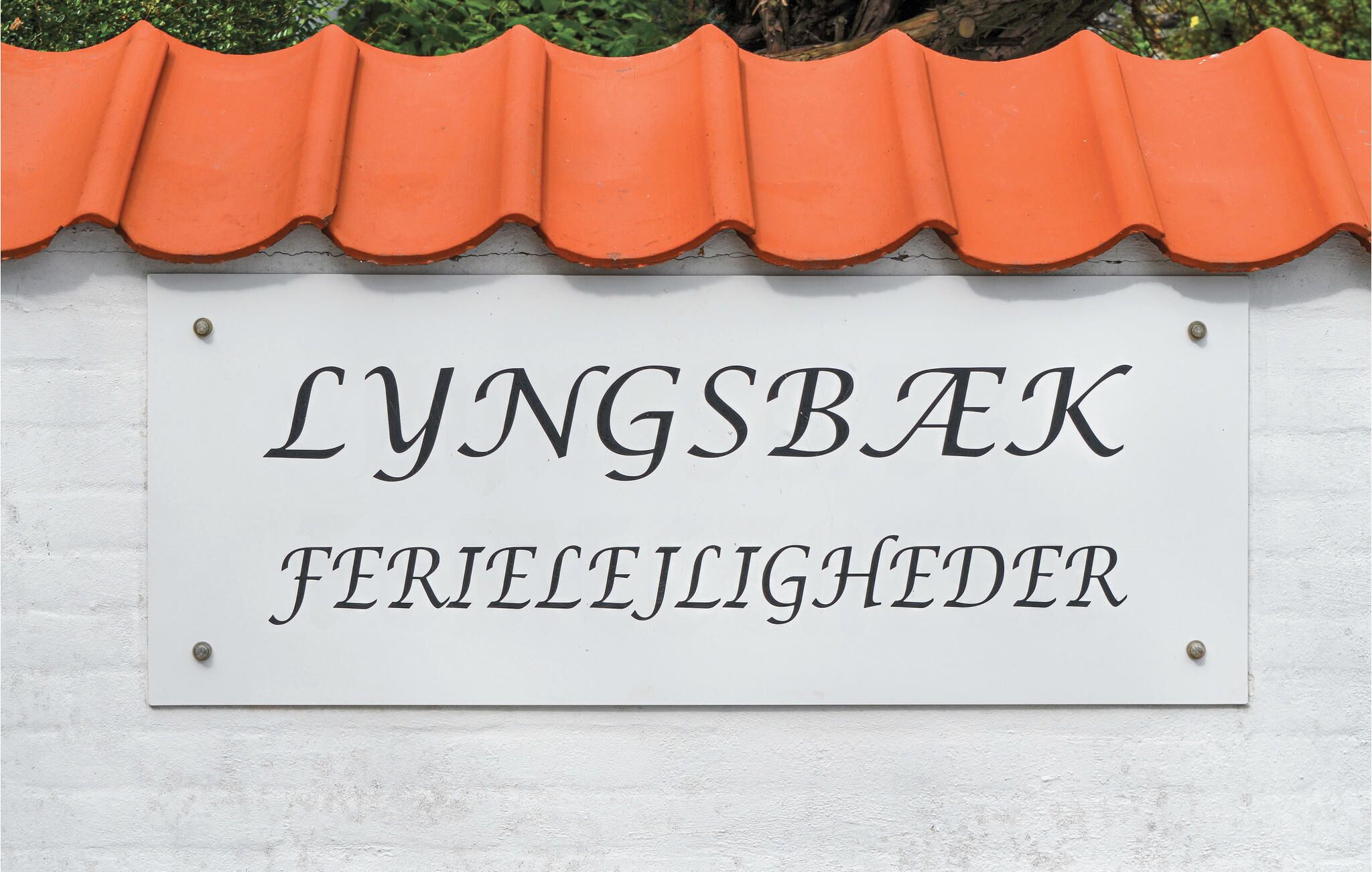 Un letrero con el texto 'LYNGSBAK' y 'FERIELEJLIGHEDER', indicando un lugar o establecimiento.