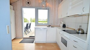 A modern kitchen with a built-in dishwasher, a stove, and a sink. There is a window with a view of greenery outside. - Awesome home in Karrebæksminde with sauna (Karrebæksminde)