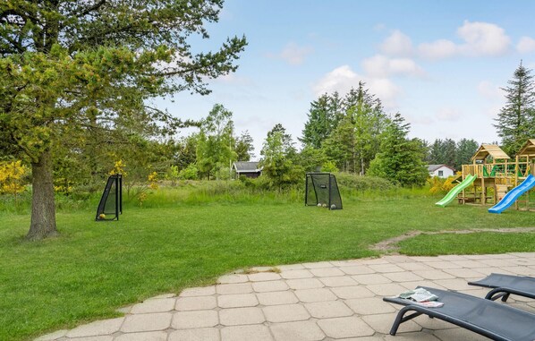 A park with a playground, picnic tables, and a grassy area.