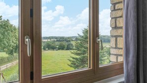 A window with a view of a green field and trees, a stone wall, and a metal handle. - Cozy home in Villers-S/s-Foucarmont (Villers-S/s-Foucarmont)