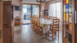 A dining area with a long table set for four, wooden chairs, and a chandelier. - Cozy home in Villers-S/s-Foucarmont (Villers-S/s-Foucarmont)
