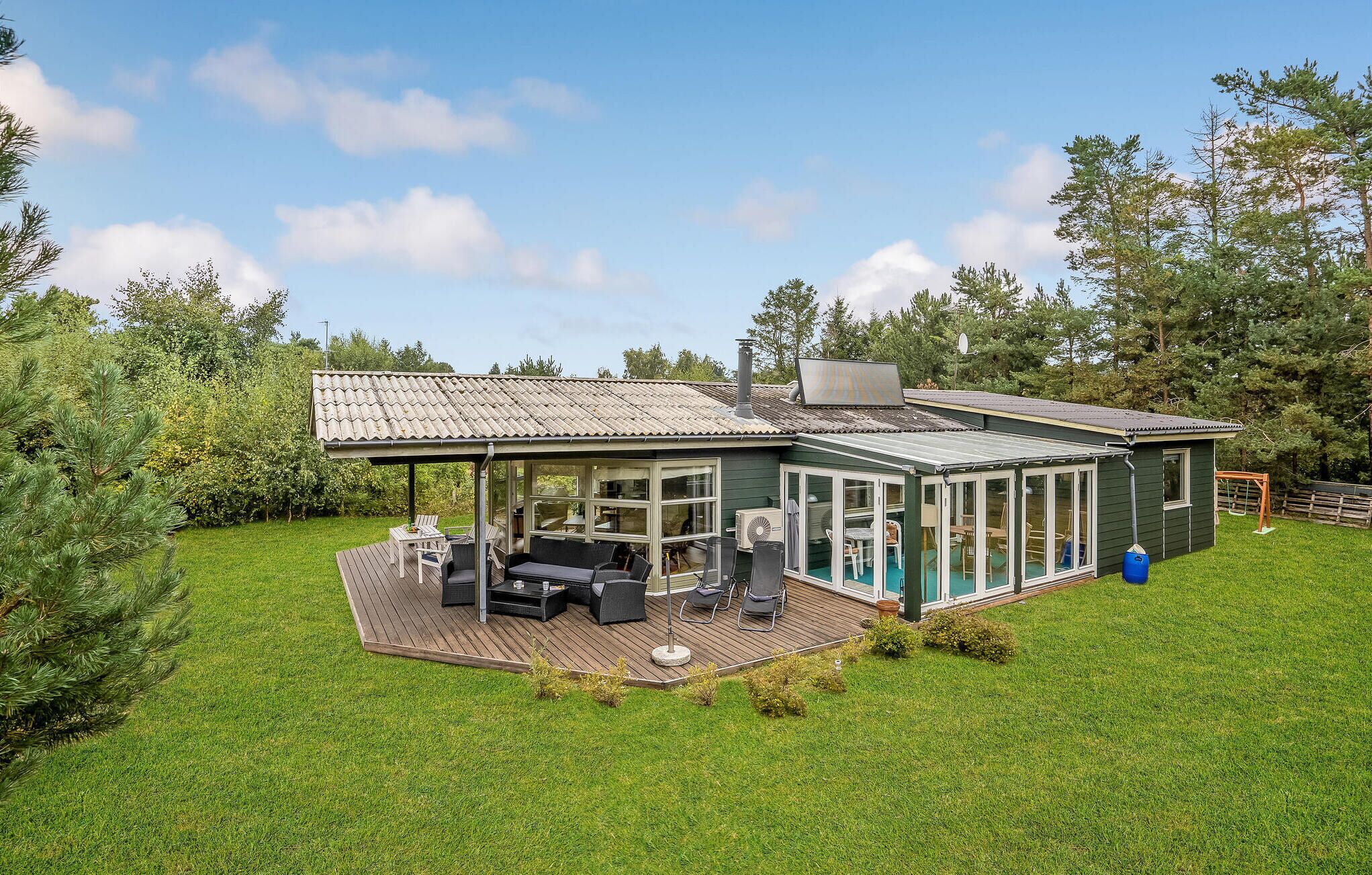 A house with a covered patio, a swimming pool, and a deck area.